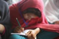 woman writing closeup red headscarf