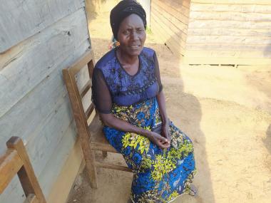 Sikuja sits on a chair in a blue top and skirt