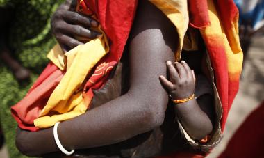 A South Sudanese mother and child attend the Join Me on the Bridge event sponsored by Women for Women International in Kubur William Payam, Lakes State, South Sudan on Saturday, March 3rd 2012. Photo Credit: Brian Sokol