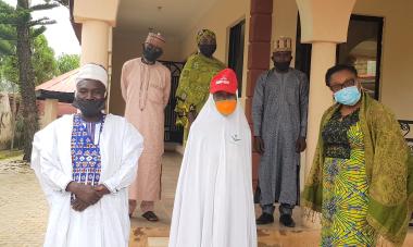 At the Women for Women International - Nigeria office, 6 people pose for the photo, including the Magama Gumau community leader and Buki Onyishi, Nigeria Country Director of our program