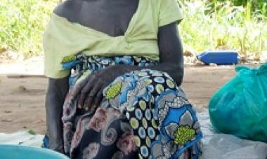 woman sitting behind a pile of mangoes